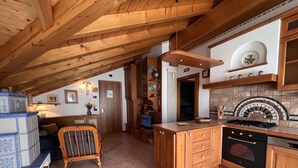 A kitchen with wooden cabinets, a tiled floor, and a built-in oven. - 004 Trilocale di Charme Giustino (Giustino)