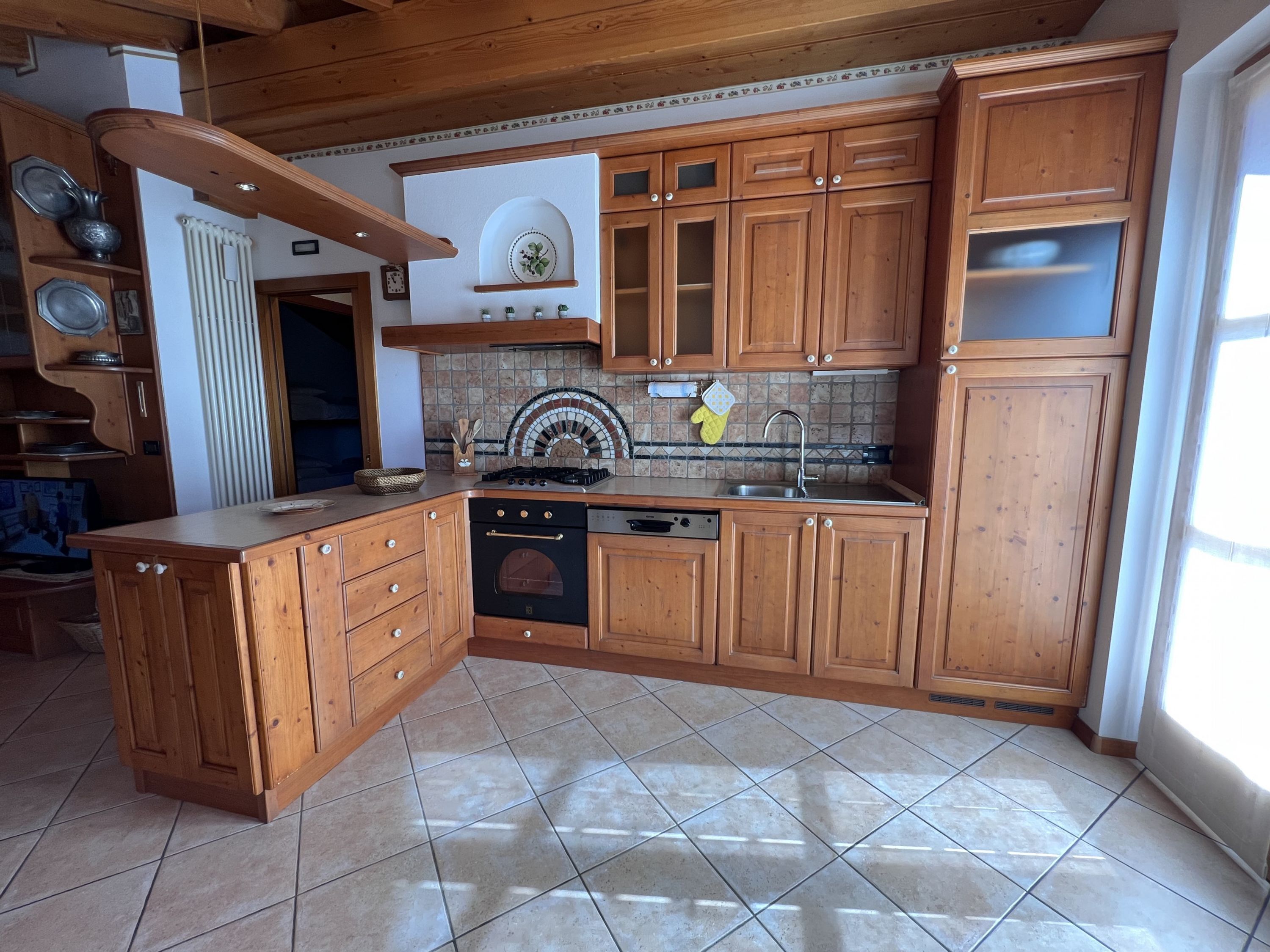 A kitchen with wooden cabinets, a tiled backsplash, a stove, and a dishwasher.
