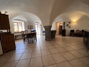 Ein geräumiger Essbereich mit Holztisch und Stühlen, einer Säule aus Stein und einem Kamin.