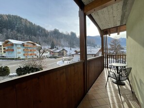A balcony with a view of a snowy village and mountains. - 093 Cond Gaiolin 26 (Giustino)