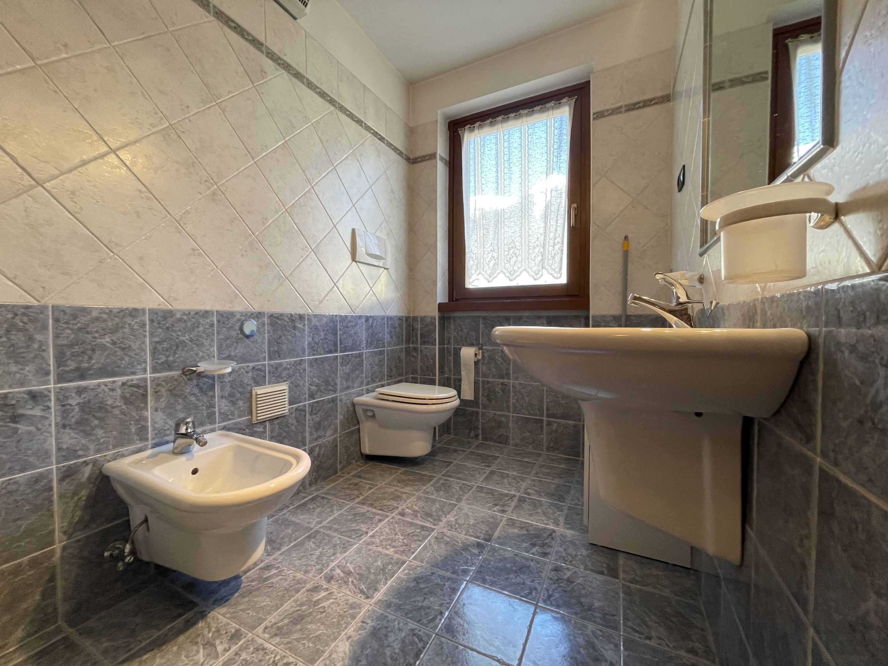 Ein Badezimmer mit Bidet, Toilette und Waschbecken.