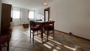 Een ruime zithoek met een eettafel, stoelen en een bank.