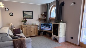 Een gezellige woonkamer met een grijze bank, een houten kast en een televisie.
