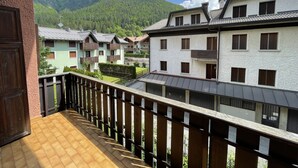 A balcony with a view of a mountain and several buildings with balconies. - 033 Trilocale Carisolo (Carisolo)