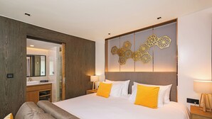 Une chambre d’hôtel moderne dotée d’un grand lit, de lambris en bois, d’un élément décoratif mural et d’une salle de bain avec un miroir et un lavabo.