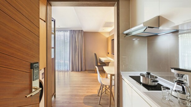Une cuisine moderne équipée d’une cuisinière intégrée, d’une machine à café et d’un coin repas avec une table et des chaises.