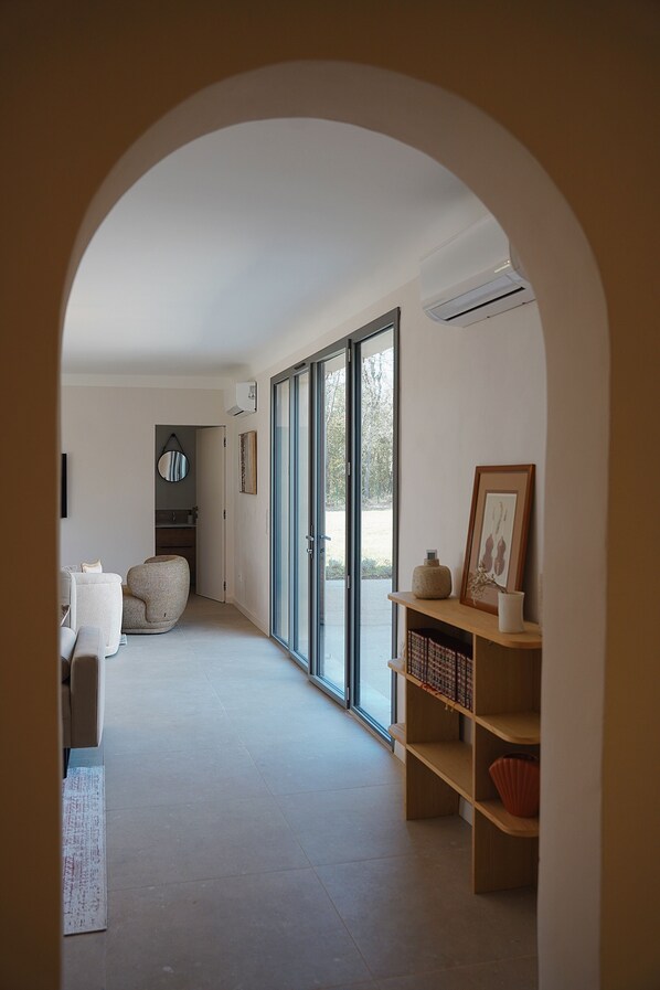 Un hall d’entrée spacieux, doté d’un intérieur moderne, d’une grande fenêtre et d’une bibliothèque intégrée.