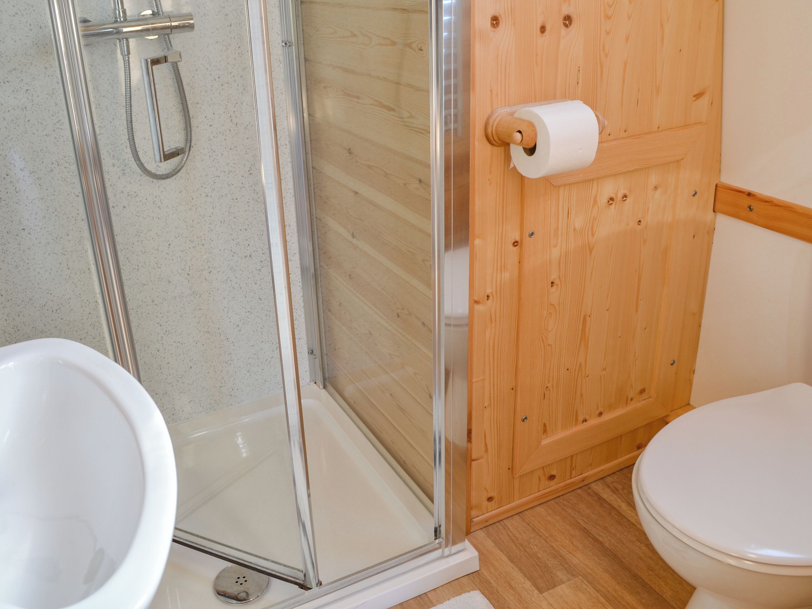 Un baño con cabina de ducha de vidrio, inodoro y bidé.