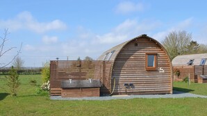 A wooden cabin with a pitched roof, a small window, and a door.