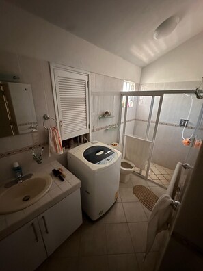 Chuveiro, toalhas de banho, sabonete, papel higiênico