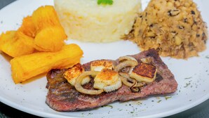 Une assiette avec un steak, de la purée de pommes de terre et une portion de maïs.