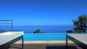 A poolside area with a view of the ocean.