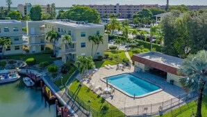 Un hôtel doté d’une piscine centrale, entourée d’une végétation luxuriante et de palmiers.