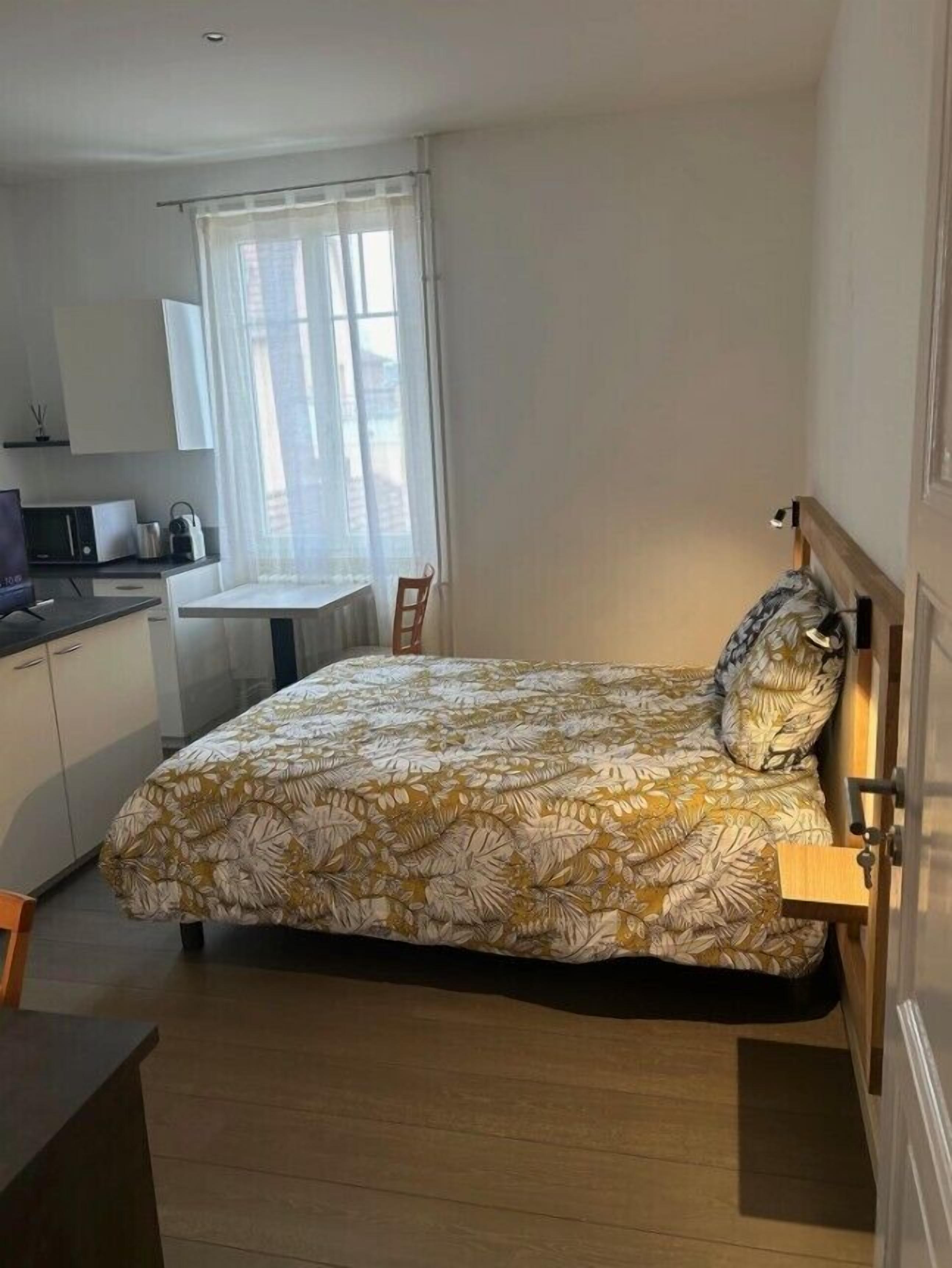 Een slaapkamer met een bed, een bureau en een stoel.
