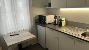 A compact kitchen with a microwave, coffee maker, and a small sink. - Salutho (Selestat)