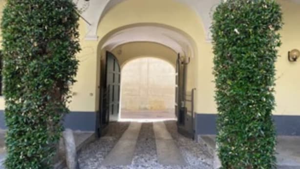 A covered entrance with a stone floor and a yellow wall.