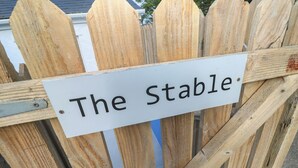 Un recinto in legno con un cartello che recita 'The Stable'.