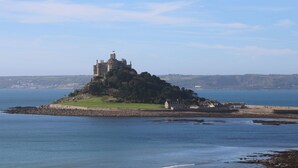 Un castello su una piccola isola circondata dall'acqua, con cielo sereno.