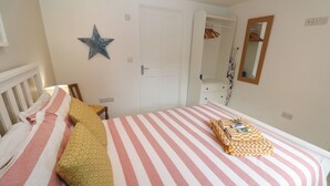Un dormitorio con cama, almohadas, una decoración con estrellas, una puerta, un espejo y un armario.
