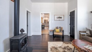 A modern living room with a wood-burning stove, a sofa, a coffee table, and a rug.