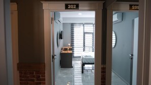 A hotel room with a bed, a desk, and a window with blinds. - Amed Sur Hotel (Diyarbakir)