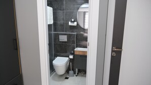 A compact bathroom with a toilet, sink, and mirror. - Amed Sur Hotel (Diyarbakir)