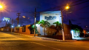 Ein Gebäude mit einer großen Beschilderung mit dem Schriftzug "RaRus" und einer beleuchteten Straße bei Nacht.