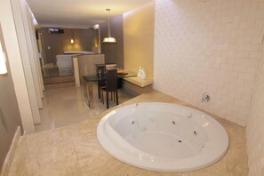 Un baño moderno con una bañera grande, una cabina de ducha con mampara de vidrio y un comedor con mesa y sillas.