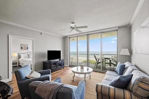 Relax in this spacious living room with a comfortable sofa set, flat-screen TV, and ocean views.