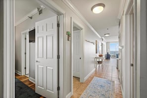 Stylish hallway with doors leading to a room featuring a large window.