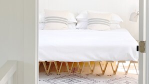 Una camera da letto con un letto, cuscini e un tappeto decorato.