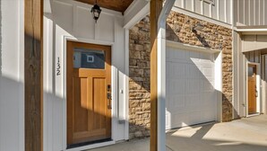 A residential house with a stone facade, a wooden front door, and a garage. - Gated Community~Brand new townhouse~Downtown Rome (Rome)