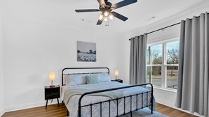 A bedroom with a bed, bedside lamps, a ceiling fan, a window with curtains, and a picture on the wall. - Gated Community~Brand new townhouse~Downtown Rome (Rome)