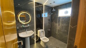A modern bathroom with a pedestal sink, a toilet, and a shower. - Coral Bay Hotel Khorfakkan (Khor Fakkan)