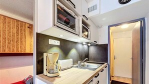 A compact kitchenette with a coffee maker, toaster, and microwave. - 100m from ski slopes, 11st floor, swimming pool, tv, ski locker, 22m², Le Corbier (Le Corbier)