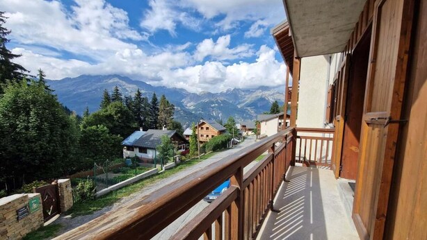 Ein Holzbalkon mit Blick auf ein Gebirge.