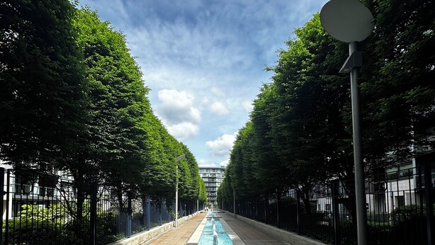 A long, narrow water feature flanked by trees and a paved walkway. - Luxury Apartment at Chelsea Bridge/Battersea Power Station (London)