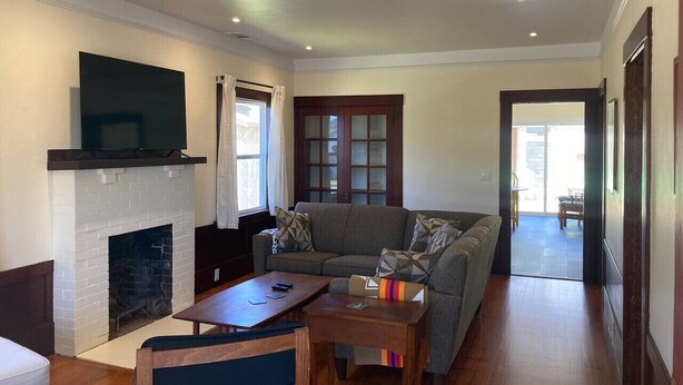A living room with a fireplace, a sofa, a coffee table, and a television. - Henderson Hideout-Hot Tub and Pet Friendly! (Eureka)