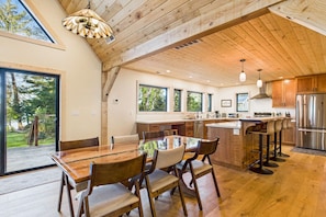 A spacious kitchen with wooden beams, a large island, and a stainless steel refrigerator. - Beautiful Ocean View Cabin and Hot Tub!! (Trinidad)
