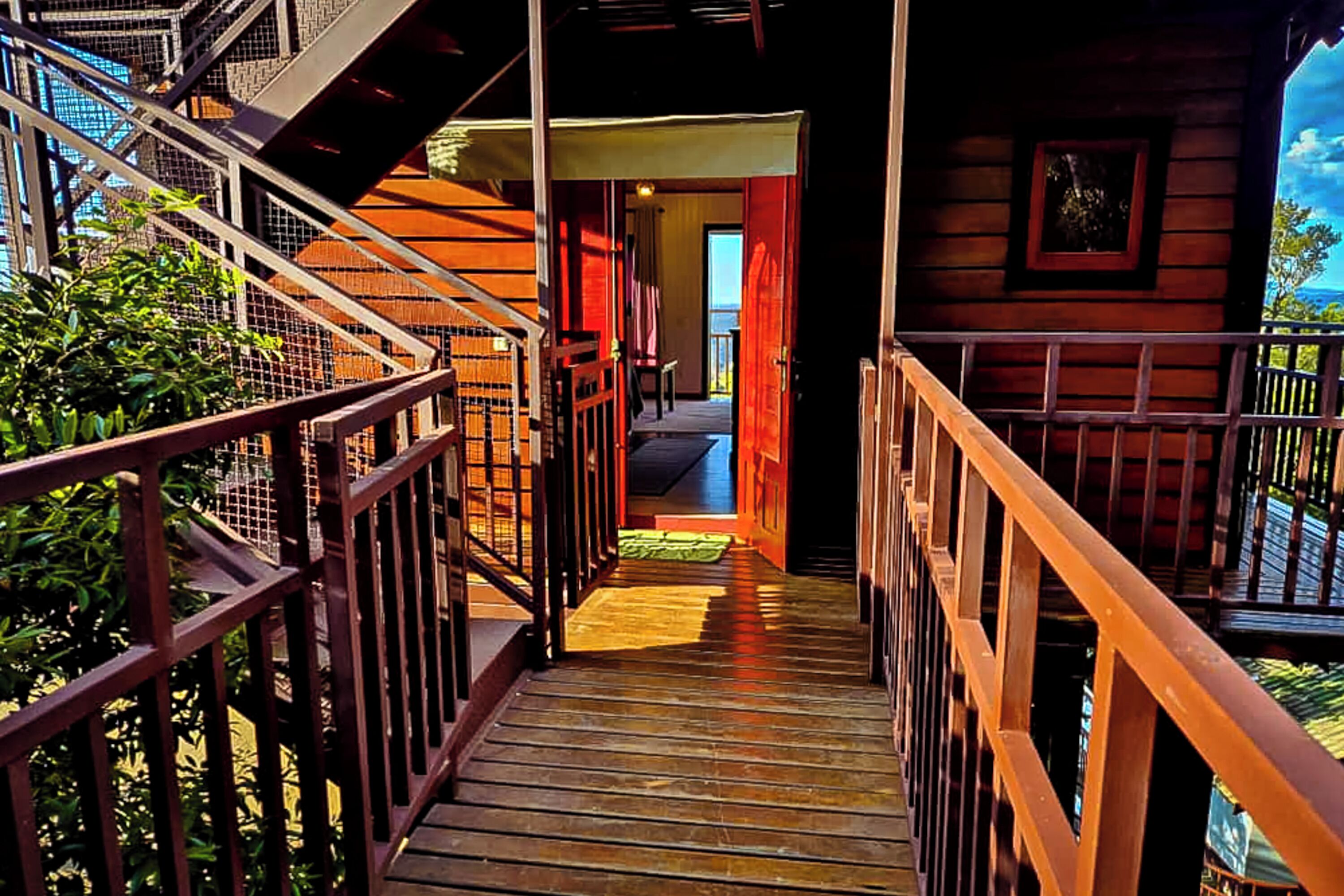 Una escalera de madera que lleva a una habitación con vistas al exterior.