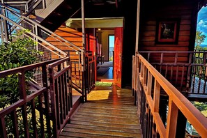 Una escalera de madera que lleva a una habitación con vistas al exterior.