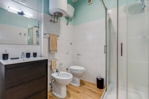 A modern bathroom with a white sink, two toilets, a bidet, and a glass-enclosed shower. - Apartment Conad - One Bedroom Villa, Sleeps 2 (Rome)
