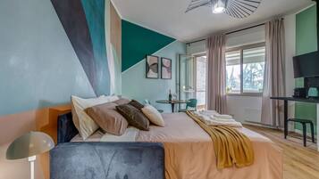 Ein modernes Hotelzimmer mit einem Bett, einem Schreibtisch, einem Sessel und einem Fernseher.