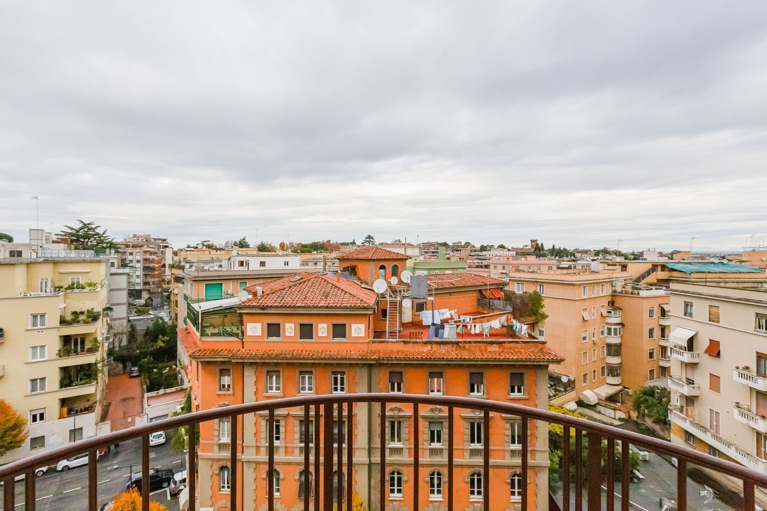 Un palazzo alto con numerosi balconi e un tetto in tegole rosse.