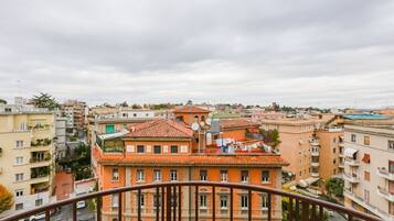 Un palazzo alto con numerosi balconi e un tetto in tegole rosse.