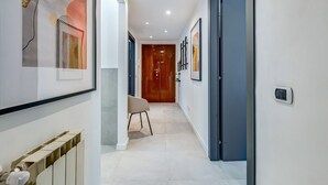 A hallway with a radiator, a chair, and framed artwork on the walls. - Apartment Apriale - Two Bedroom Villa, Sleeps 5 (Rome)