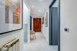 A hallway with a radiator, a chair, and framed artwork on the walls. - Apartment Apriale - Two Bedroom Villa, Sleeps 5 (Rome)