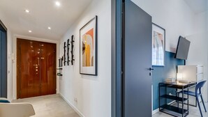 A modern hallway with a wooden door, a desk with a chair, and framed artwork on the walls. - Apartment Apriale - Two Bedroom Villa, Sleeps 5 (Rome)