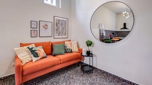 A modern living room with a sofa, a round mirror, and artwork on the wall. - Velcro Apartment - Three Bedroom Villa, Sleeps 7 (Rome)