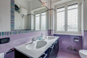 Ein Badezimmer mit zwei Waschbecken, einem großen Spiegel und einem Fenster.